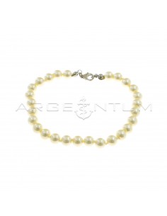 Bracelet of ø 6 mm pearls strung in knots with white gold plated terminals and snap hook in 925 silver